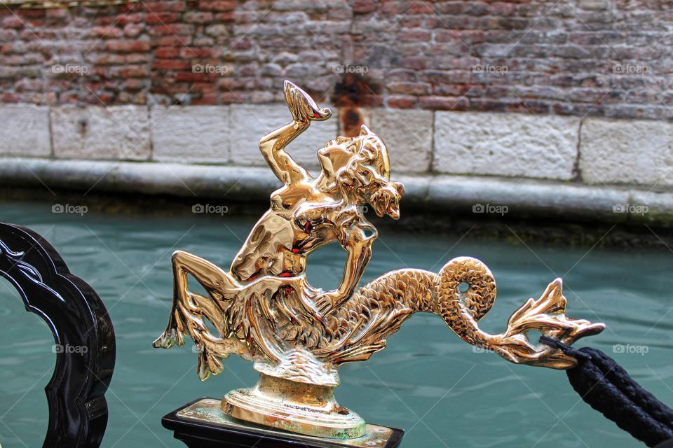 figure of a golden mermaid on a background of water. Florence in detail