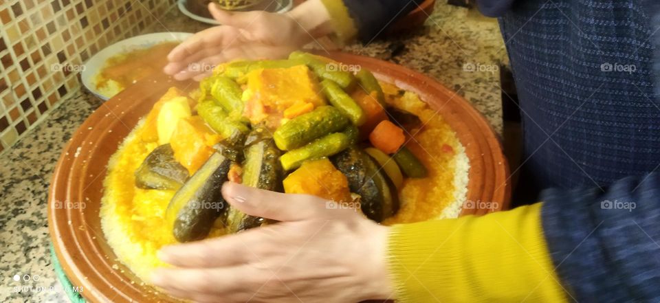 human hands and plate of COUSCOUS