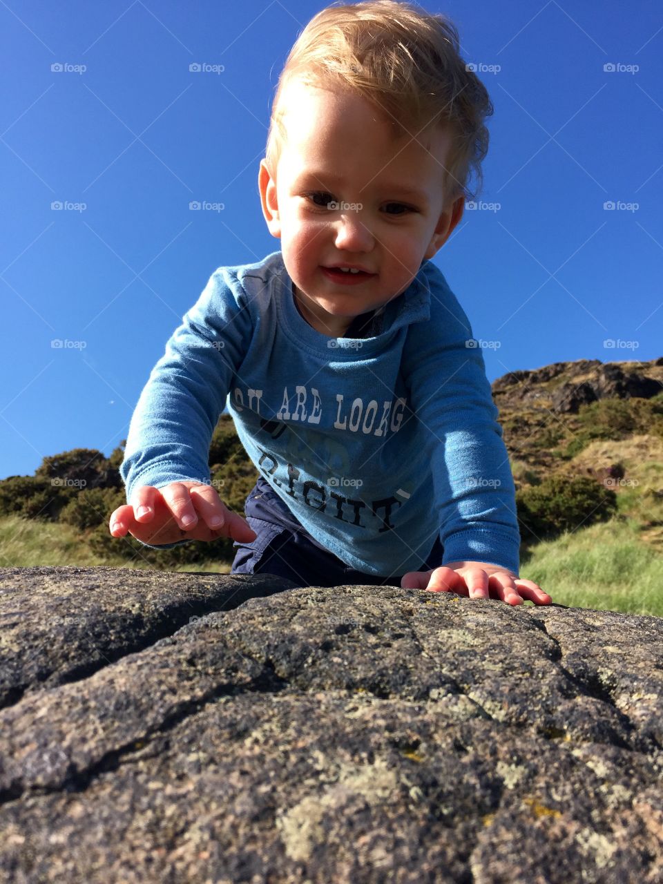 Close-up of a child playing on rock