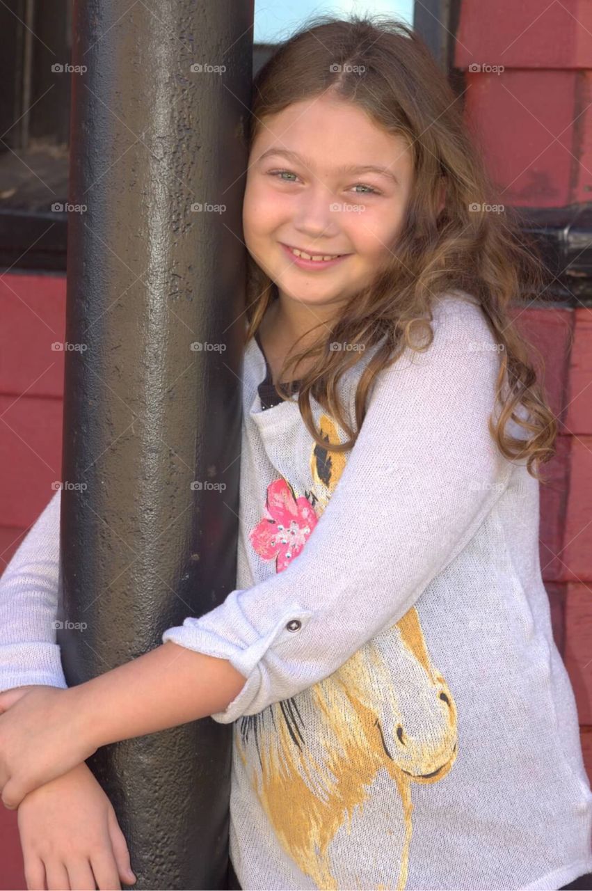 Girl standing and holding metallic pole