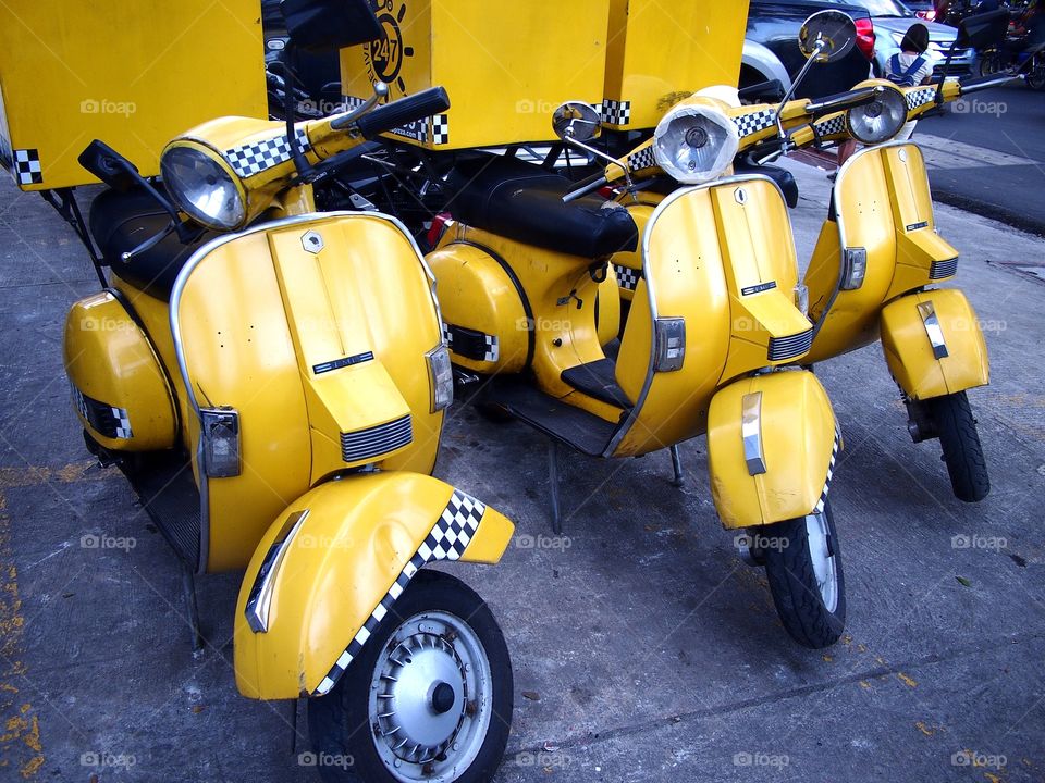 parked yellow colored delivery motorcycles