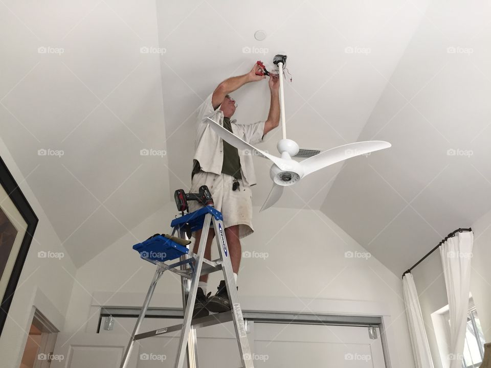 Man working hanging a ceiling fan