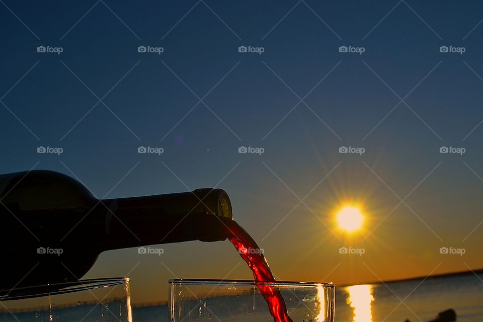 Pouring red wine at sunset. Pouring red wine (Shiraz!)at sunset in south Australia. 