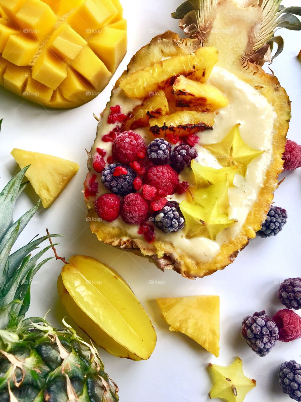 Healthy tropical breakfast- grilled pineapple berries mango and pineapple yogurt smoothie bowl 