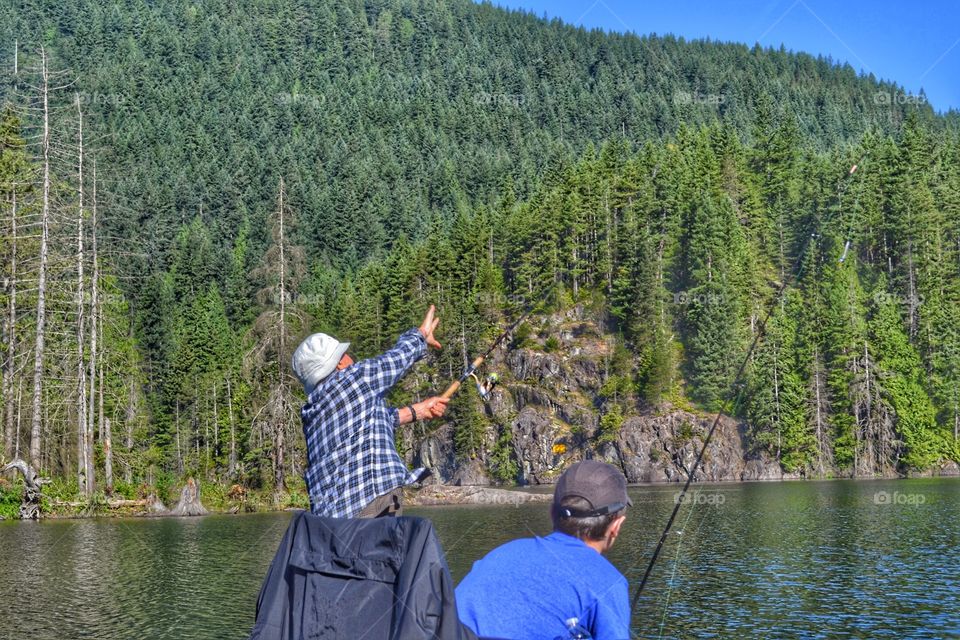 Fly fishing with grandfather. Fly fishing with grandfather, grandson watches as grandfather casts his line