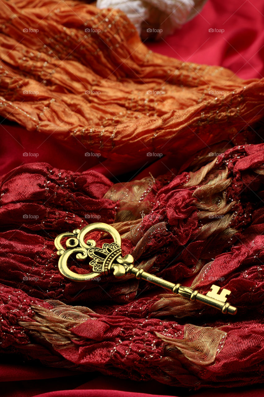 Golden antique key on red luxury fabric