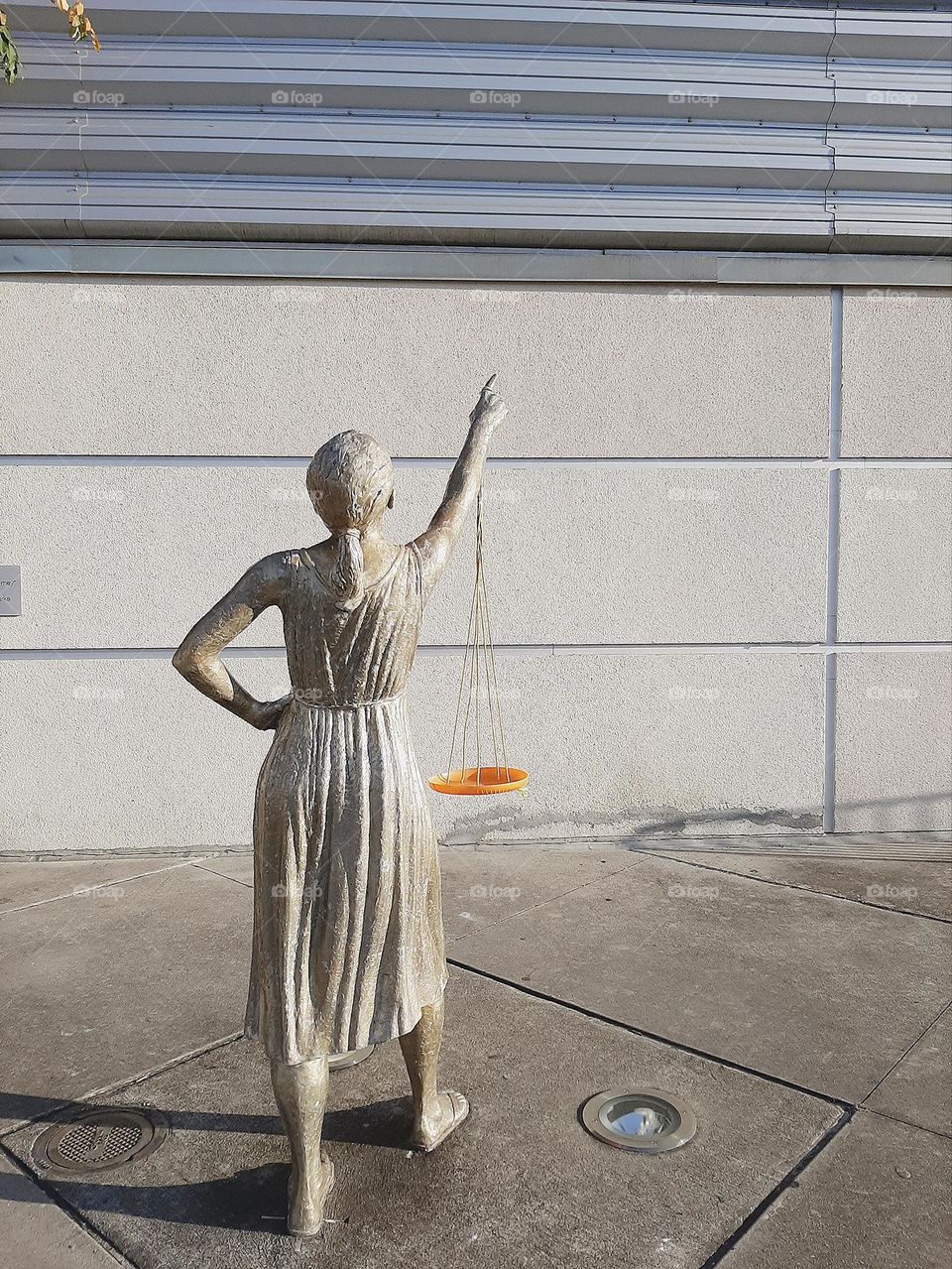 Female metal statue pointing hand.