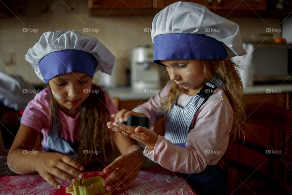 Little sisters cooking the biscuits 