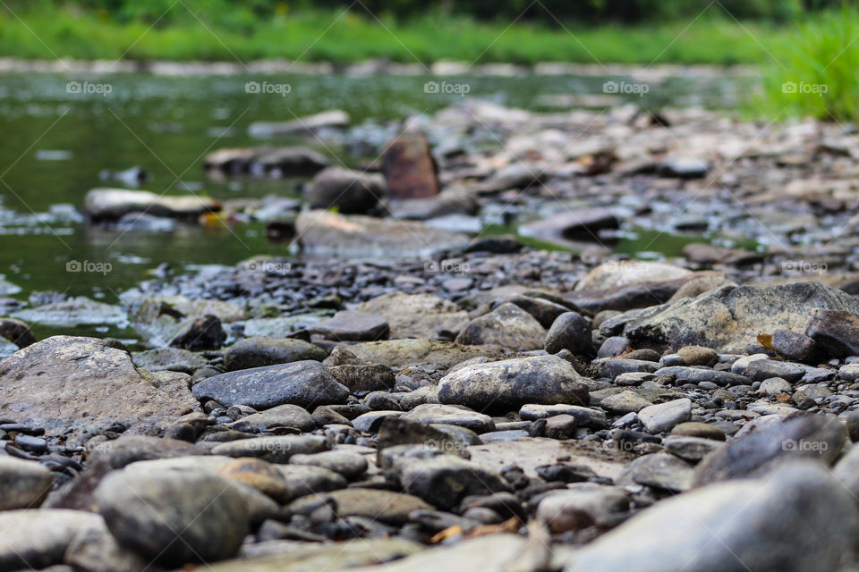 small rocks and pebbles line the creekside