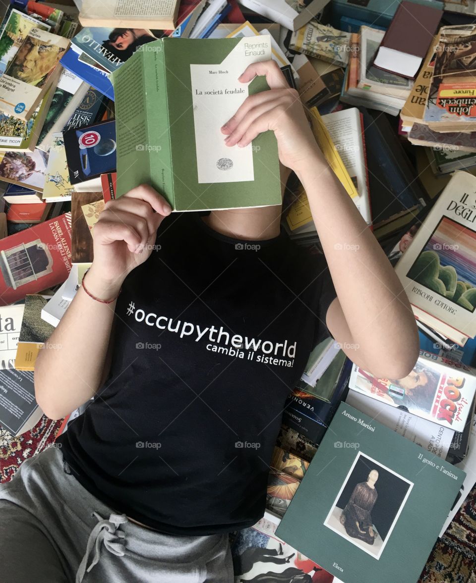 a girl is intent on reading lying on a bed of books