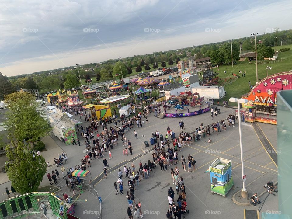 Crowds of people in line for rides at a carnival taken from the Farris wheel 