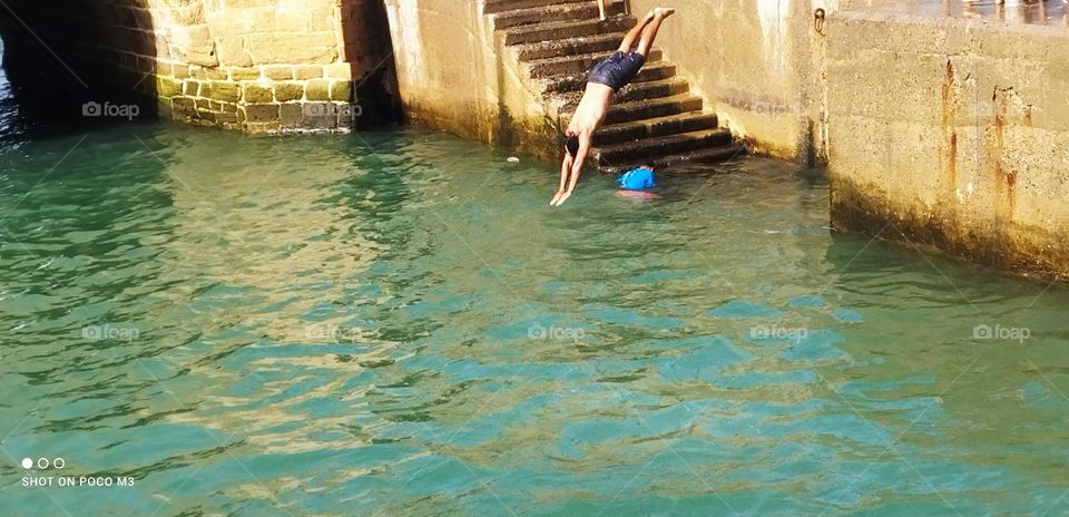 splendid jump into water at essaouira Harbour in Morocco.