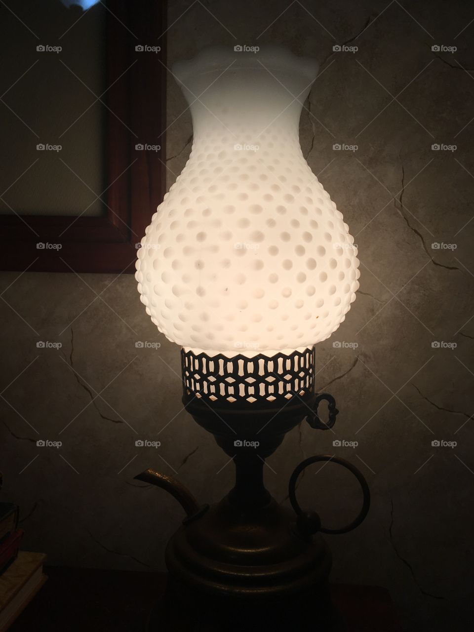 Hobnail milk glass globe on a vintage oil lamp for soft ambient lighting.