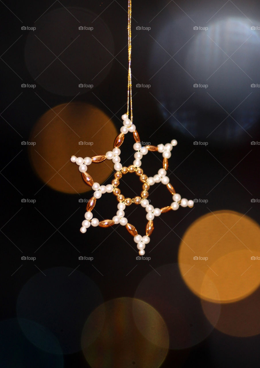 star pendant for christmas with distant lights in the background