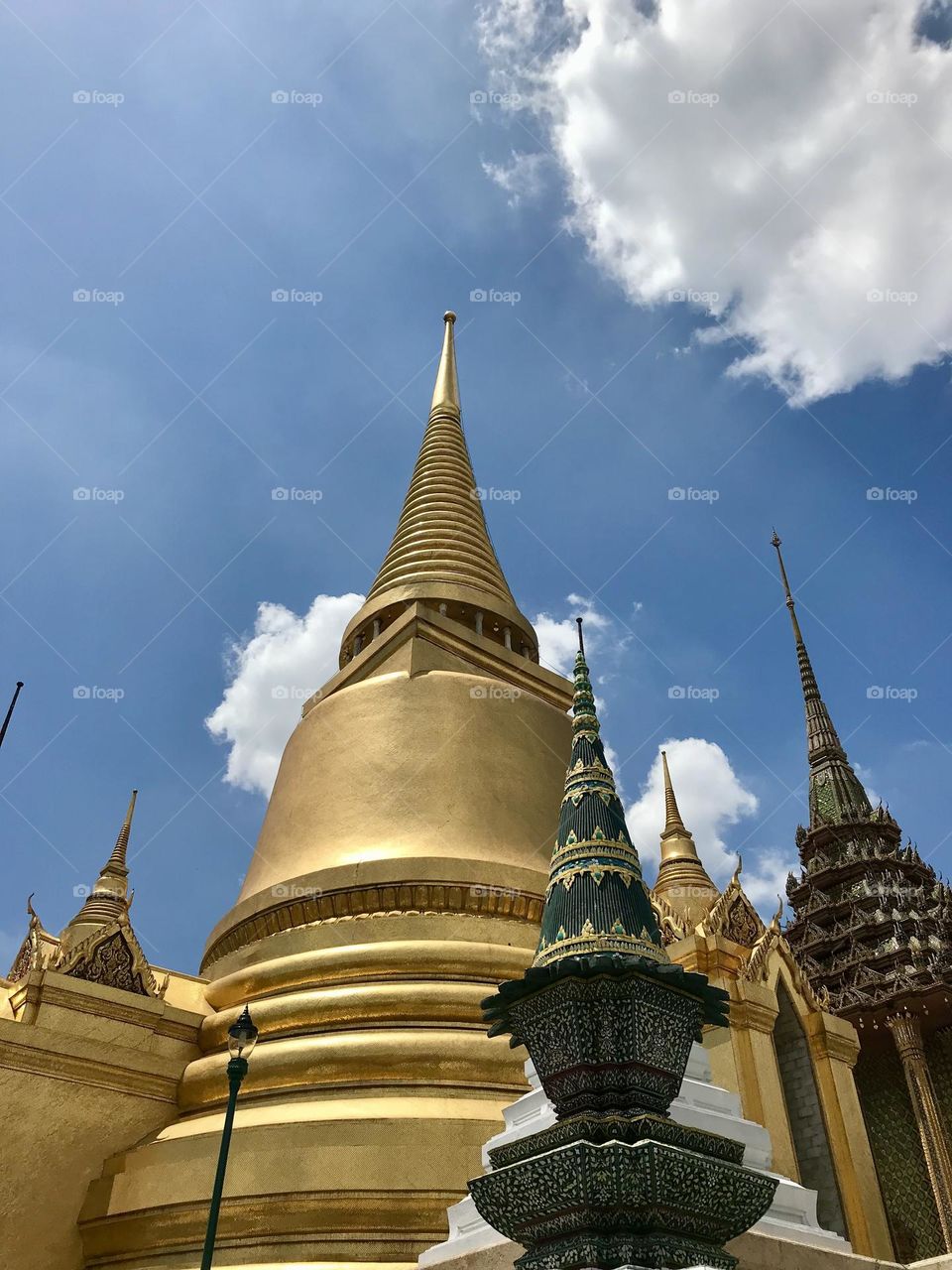 Several different golden and decorated pagodas against blue sky in Bangkok, Thailand 