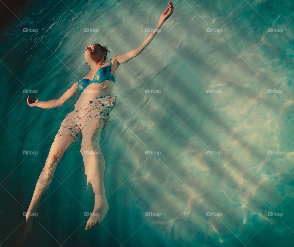 Floating in the pool under the shade of large palm fronds