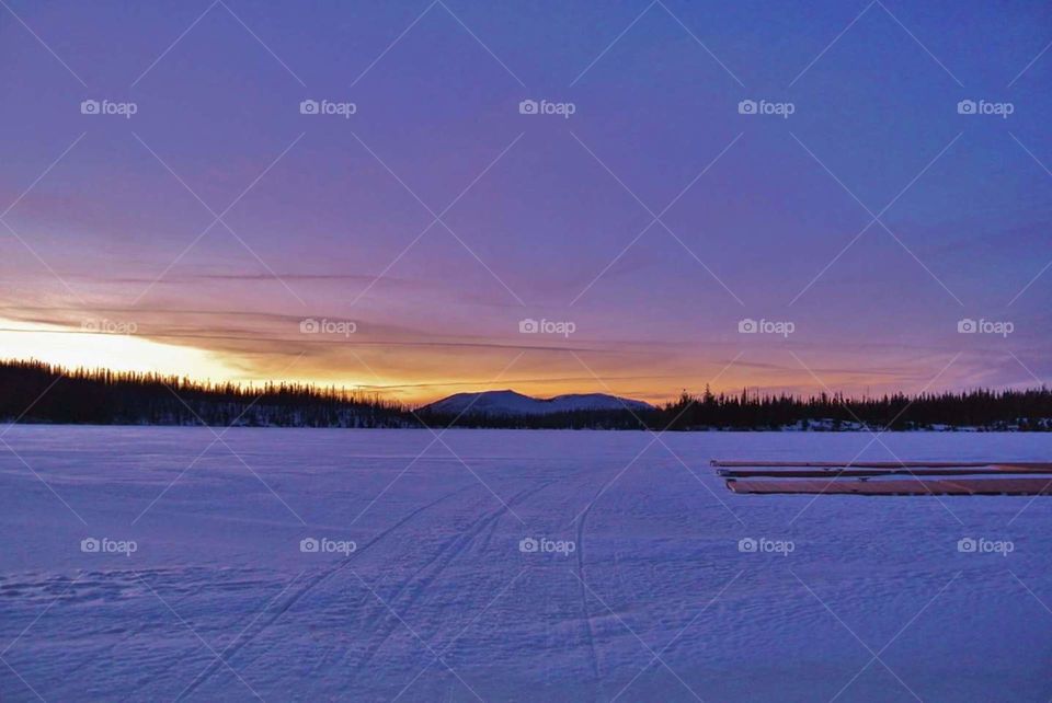 Snow covered lake at sunset