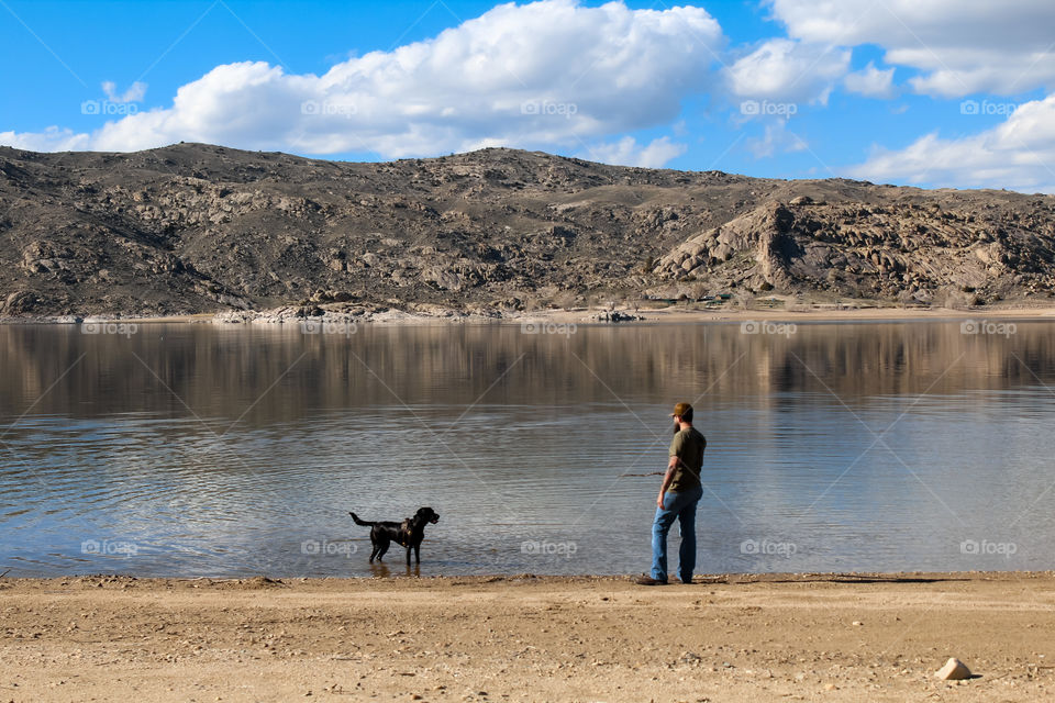 Playing with black lab dog lake scenic Mountain dirt rocks