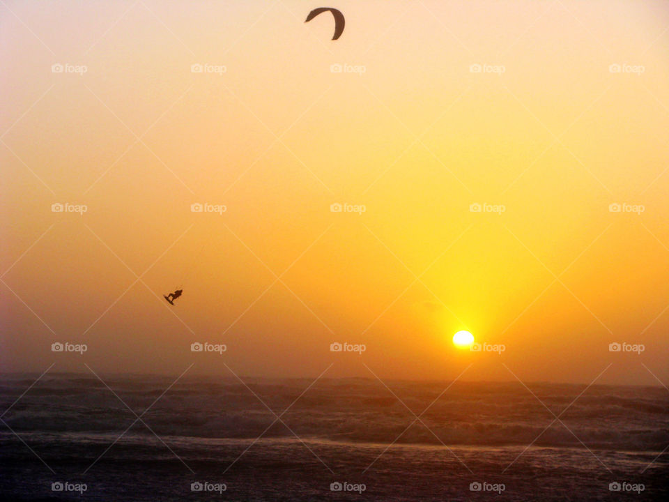 Silhouette of a kite boarder at sea