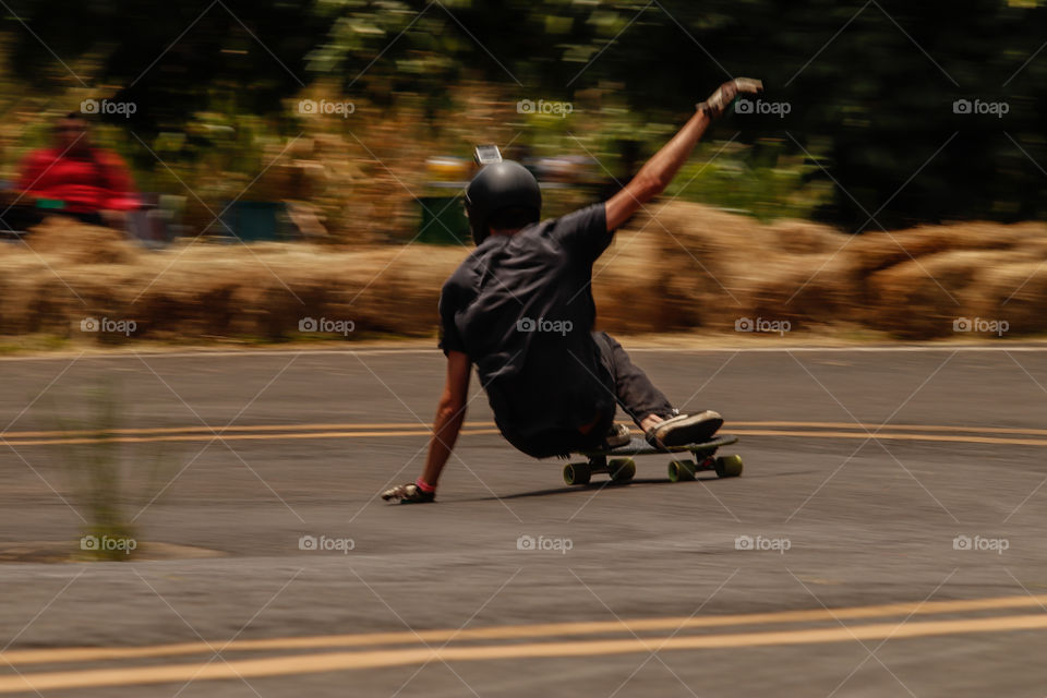 Skatista descendo ladeira em alta velocidade.