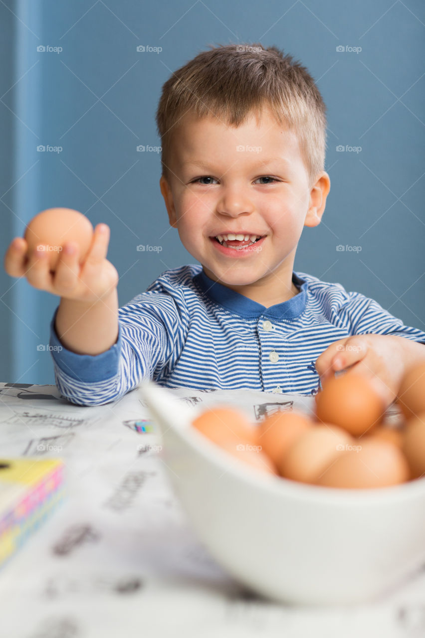 Young boy counting boiled chicken eggs 