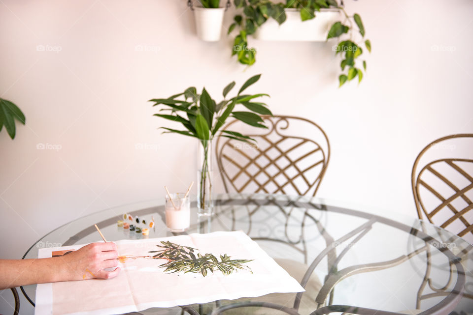 Person painting a portrait of a houseplant 