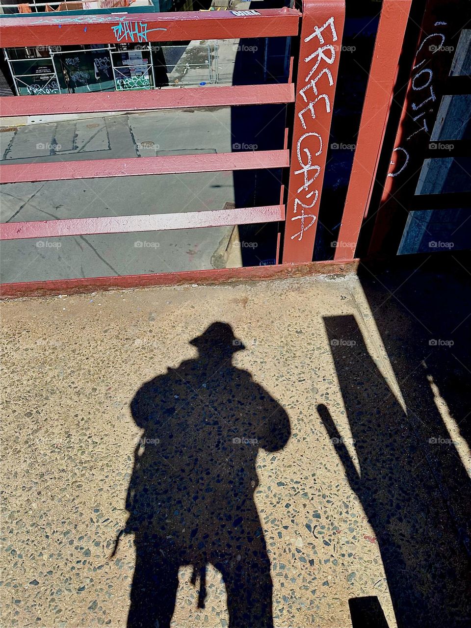 The red metal staircase of the “Pulaski Bridge” at “Newtown Creek” often paints dramatic shadows of pedestrians on its asphalt platforms. 2024. Hypnotic Productions