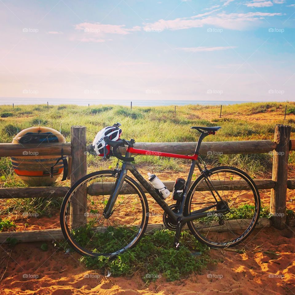 Choices choices - bike and surfboard at the beach in the summer sun