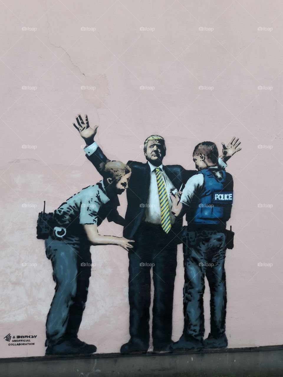 Donald trump being frisked (street art)