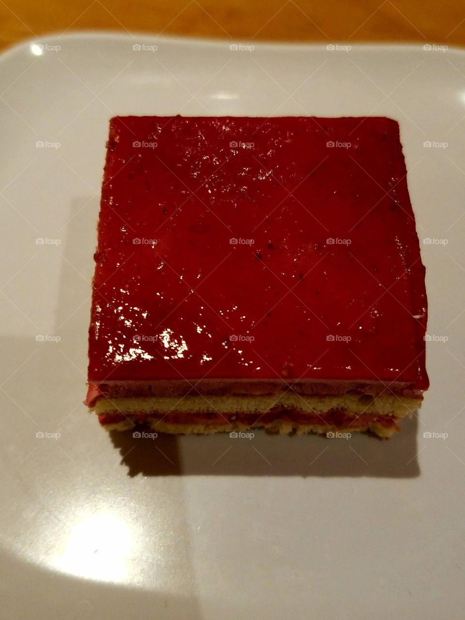 red layered cake with a strawberry glazed topping