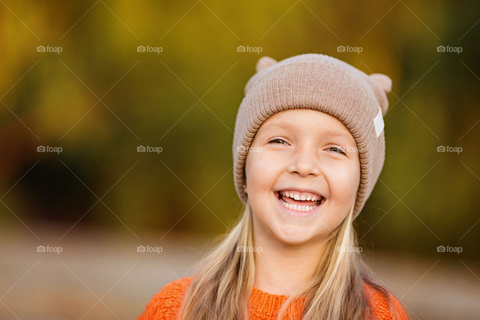 Cute little girl with blonde hair smiling outdoor 