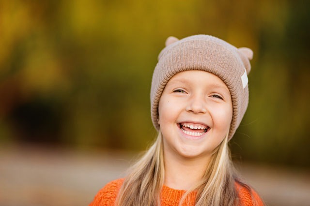 Cute little girl with blonde hair smiling outdoor 