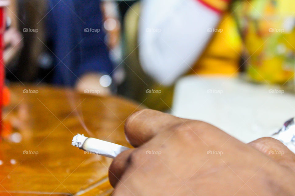 hand holding cigarette. hand holding cigarette in a night party