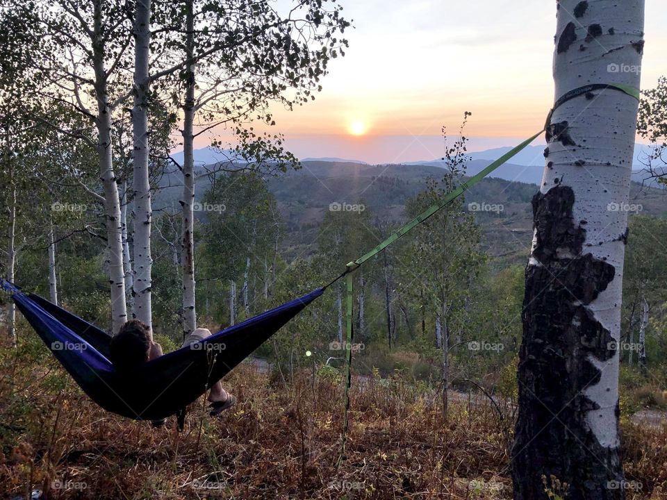 Relaxing in a hammock as the sun sets over the mountains in northeast Utah 