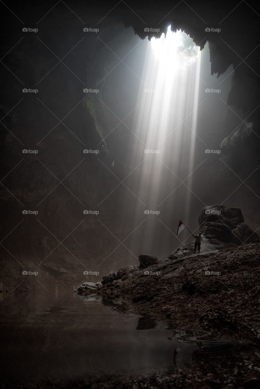 A person holding flag inside the cave