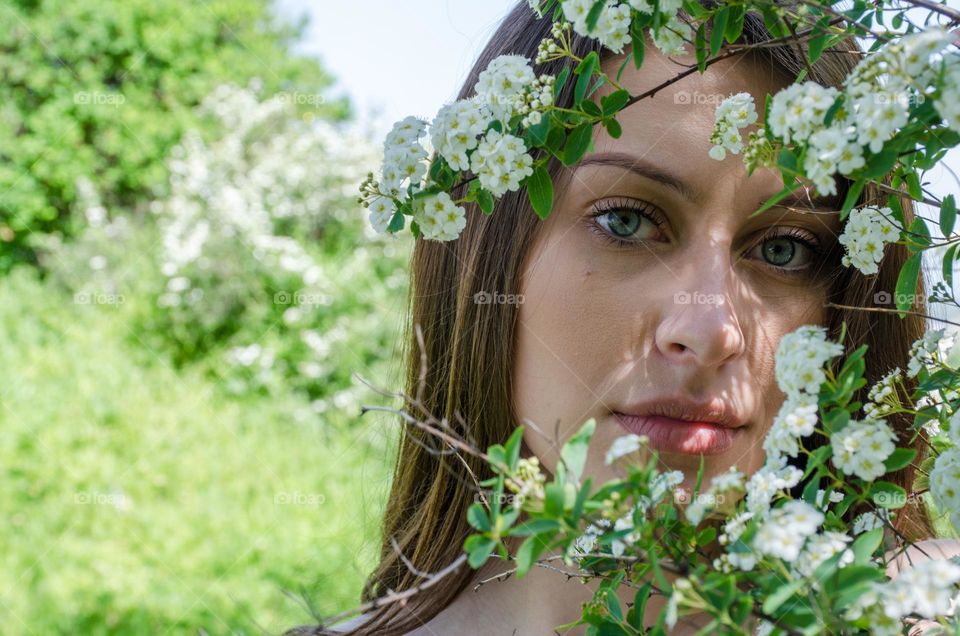 Portrait of a Beautiful Young Girl on Background of Flowers