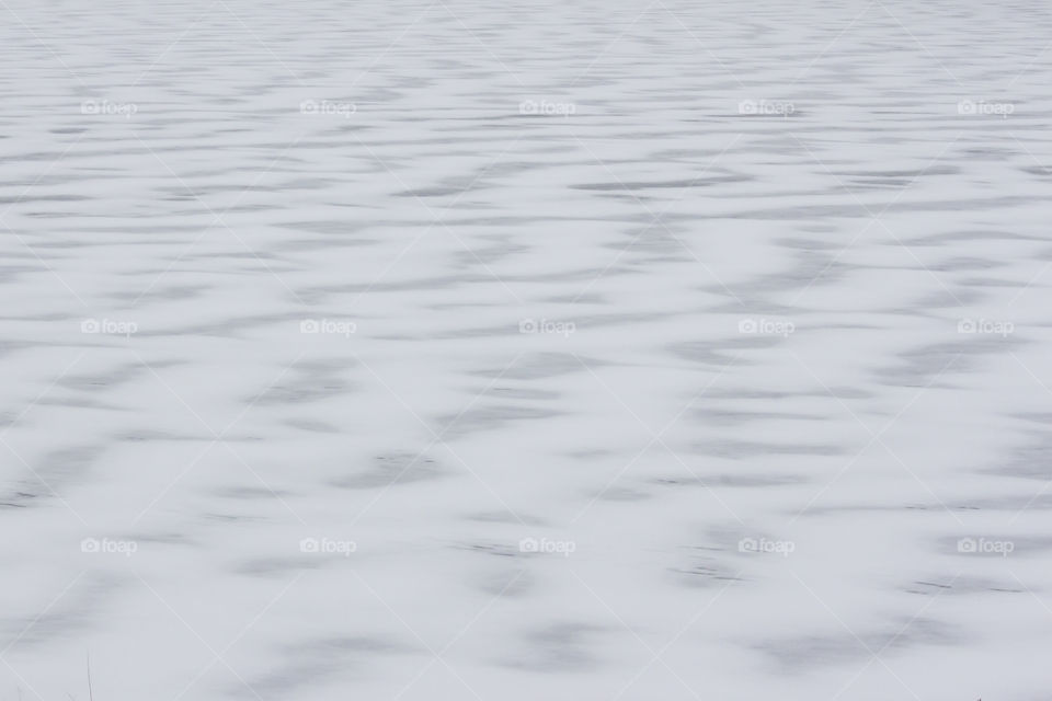 Snow wave pattern on frozen lake 