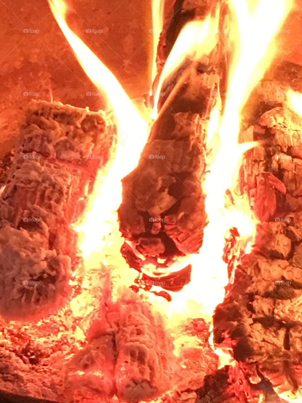 Wood logs burning with flames on a fire in a chiminea in the garden 