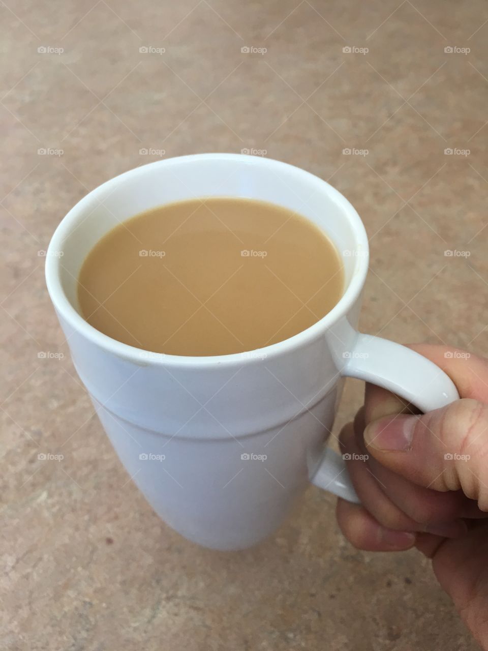 Hand holding a cup of coffee.