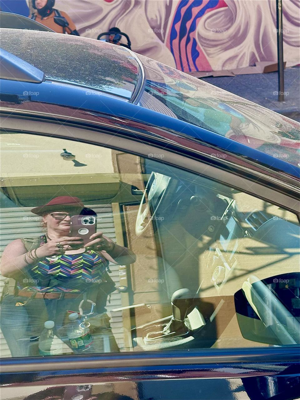 Reflections can be seen on “Jefferson St” in “Bushwick”, Bklyn. I, the photographer am visible in a mirrored car window and the fabulous Latin “PRIDE” mural across the street again reflects in the metallic blue car roof. 2024. Hypnotic Productions