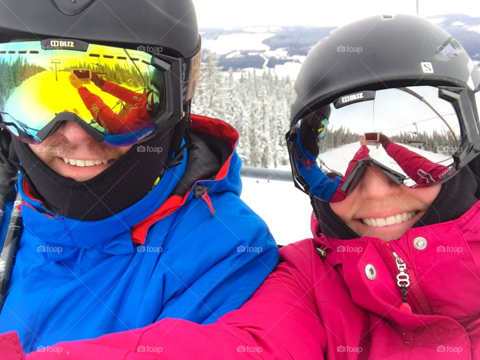 Skier couple taking selfie with smart phone