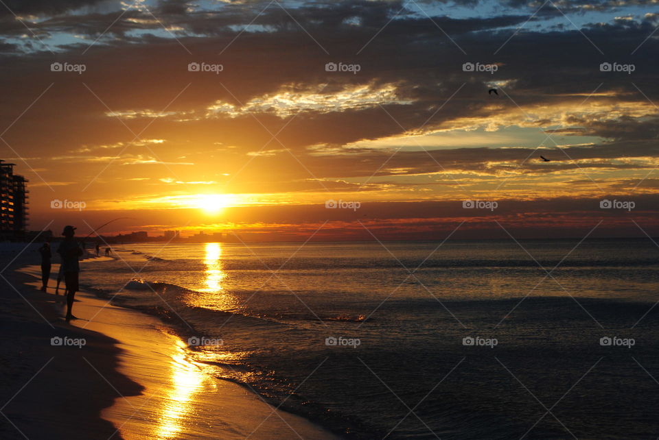 People fishing at the beach at sunrise in Destin, Florida