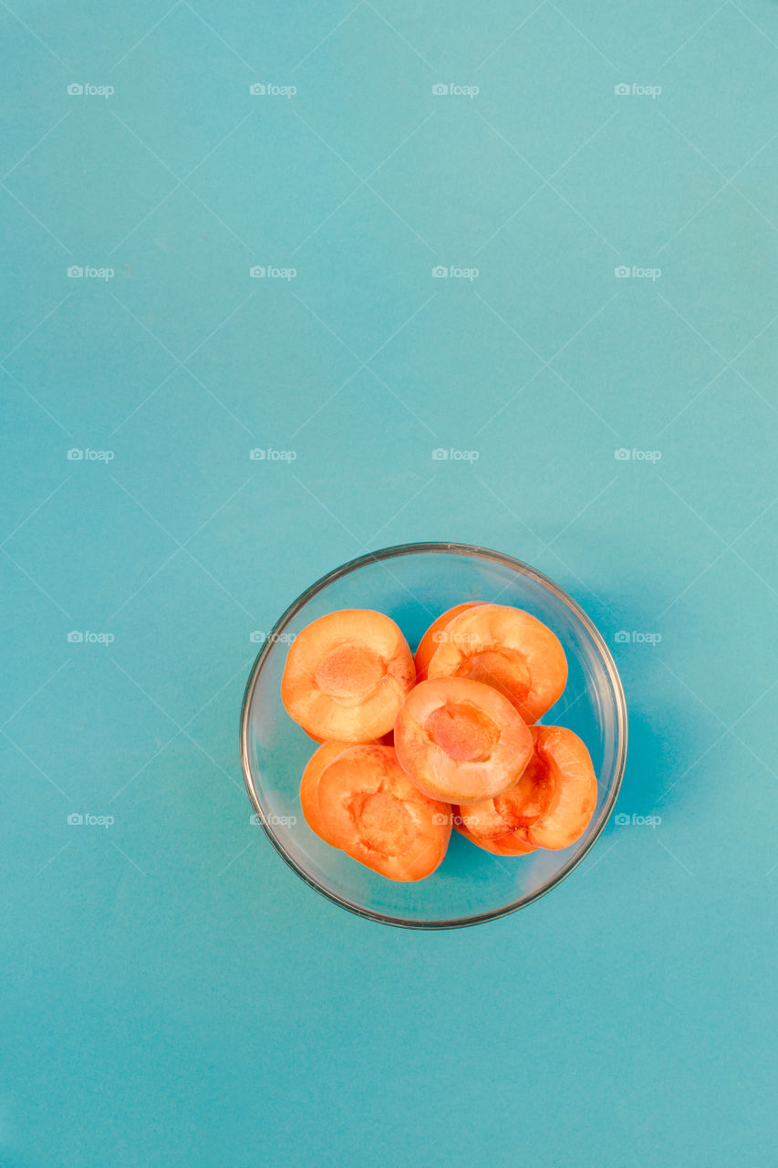 Apricots in bowl on blue