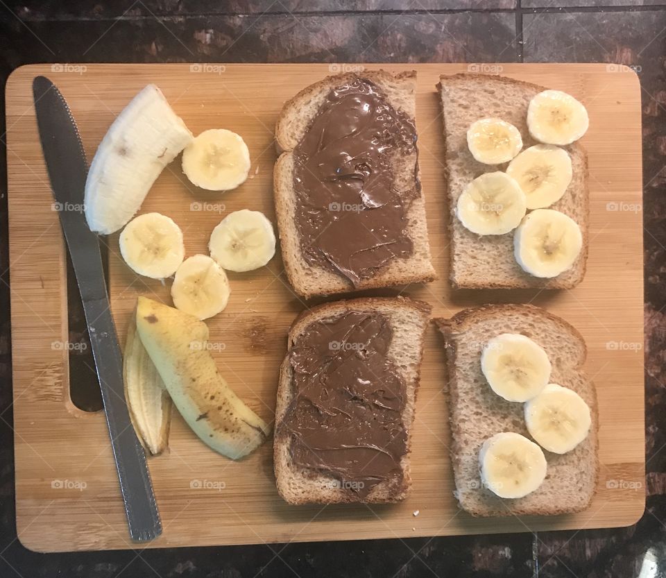 Preparing Nutella and banana sandwiches for lunch on a cutting board in the kitchen. USA, America 