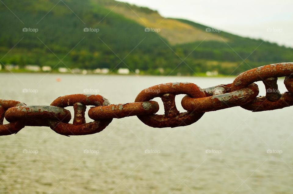 Close-up of chain against lake