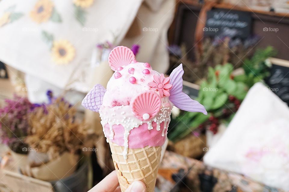 Mermaid ice-cream. Strawberry cheesecake ice cream cone decorated with seashell and fish tail in fantasy mermaid concept.