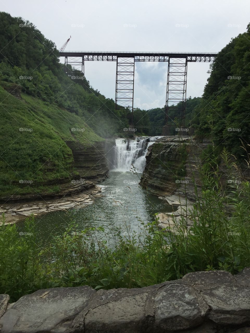 Water falls at Letchworth Park in New York with train trestle built in 1875  over the top of the falls.