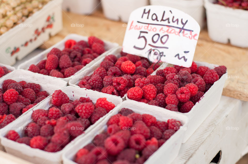 Ripe raspberries in boxes on market