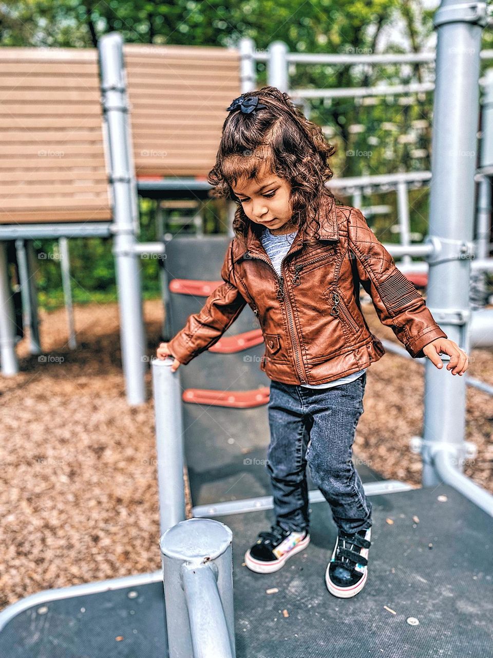 Toddler girl climbing on playground equipment, toddler plays outside in the summer, enjoying the outdoors with children, toddlers and the outdoors, playing outside 