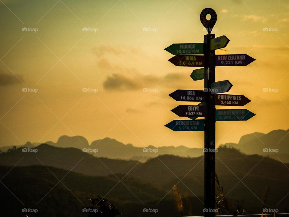 Direction signs on top of the hill with beautiful sunrise background and the mountains 